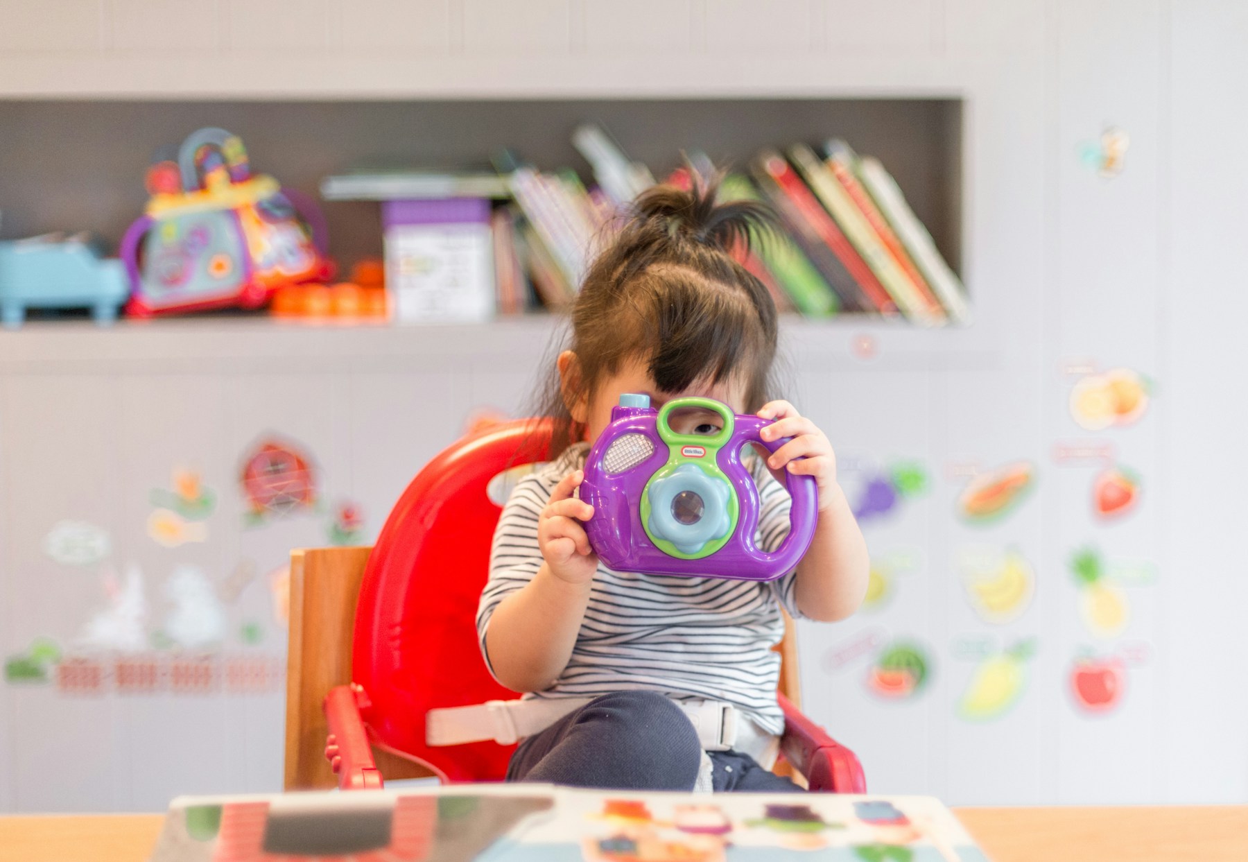 Criança brincando com uma câmera de brinquedo